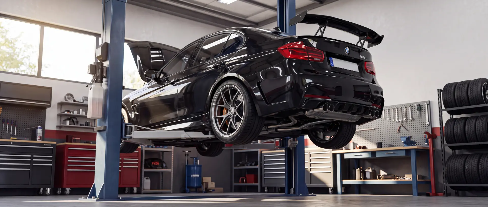 Schwarzer BMW mit Heckspoiler auf der Hebebühne in der Werkstatt bei der Sonderbegutachtung (Vollgutachten & Einzelabnahmen)