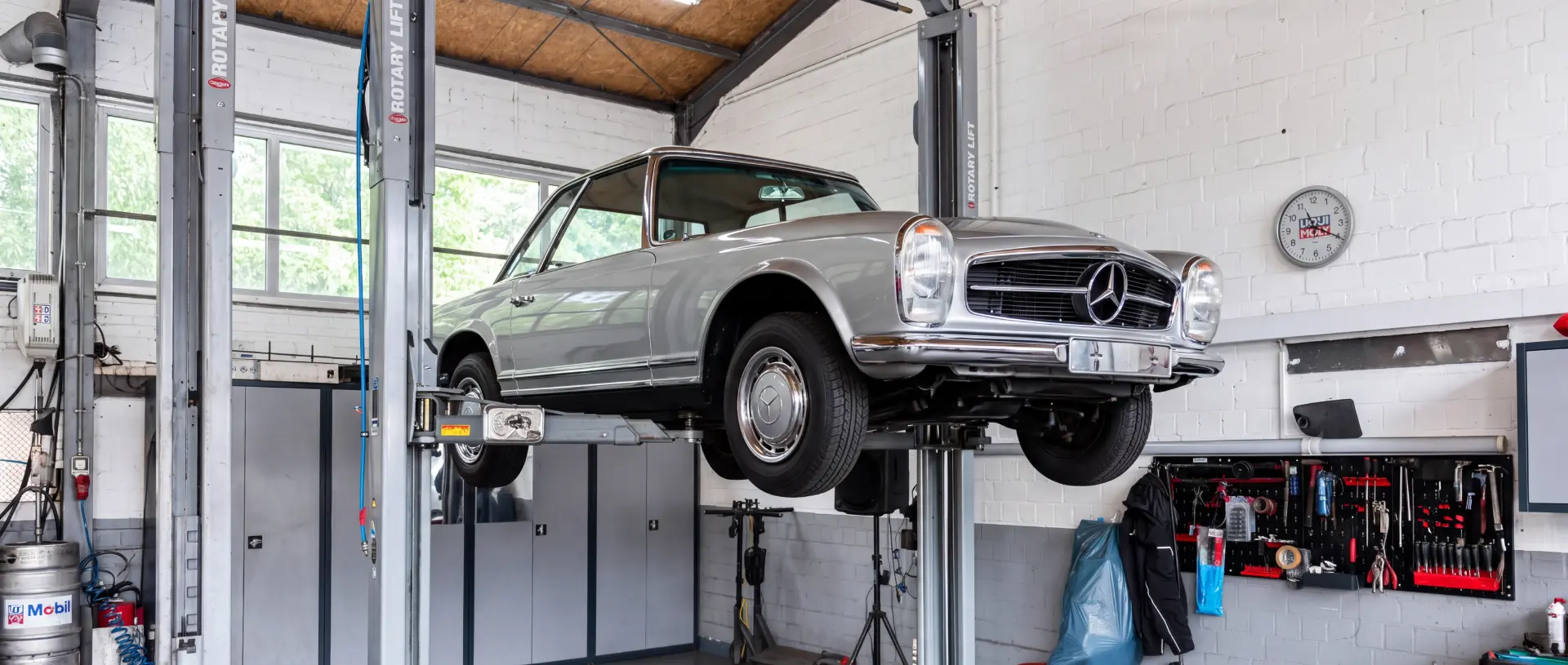 Klassischer Mercedes SL Oldtimer auf der Hebebühne in der Werkstatt bei der Zustandsbewertung