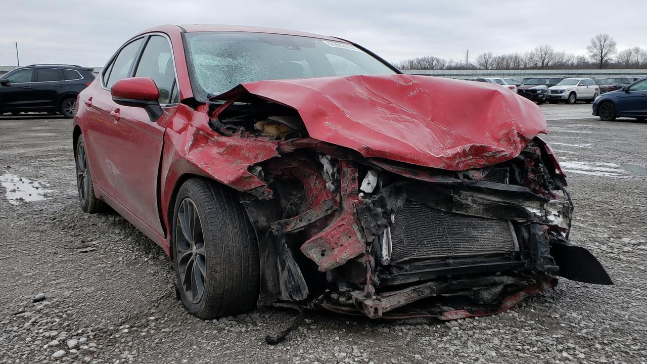 Rotes Unfallfahrzeug mit stark zerstörter Front auf einem Abstellgelände